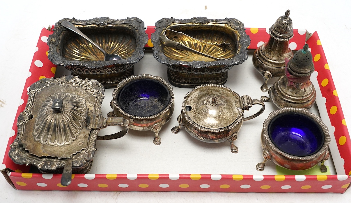 A George III silver three piece condiment set, Story & Elliot, London 1810/11, together with a George V silver five piece condiment set, Harrod's Ltd, London, 1911. Condition - fair